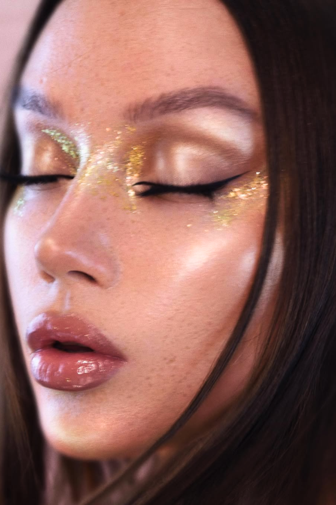 gold shimmer makeup look with radiant skin and warm glowy highlight