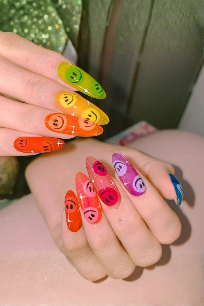 Smiley face funky nails with colorful base and cute trendy nail art design