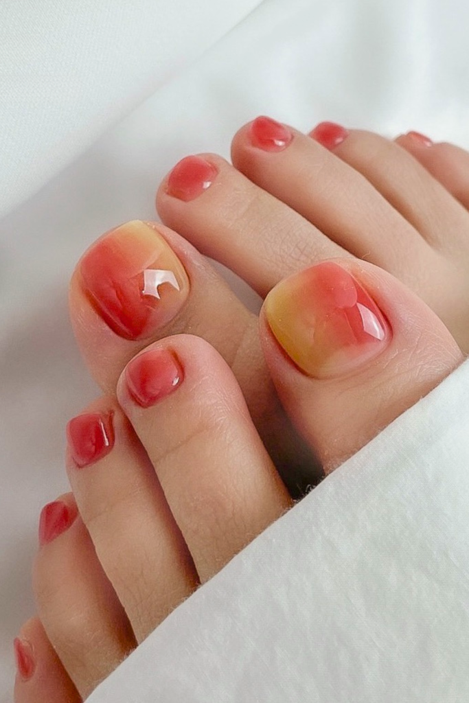 sunset ombre toe nails with warm gradient colors, aesthetic summer pedicure design for soft blended nails
