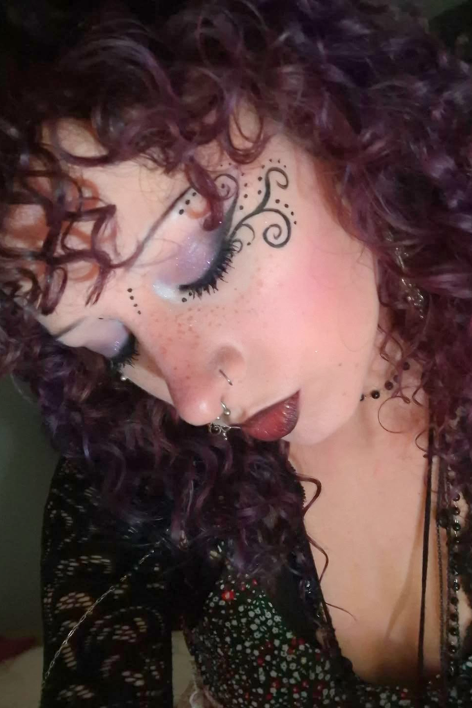 whimsy makeup with dark tones, glossy skin and glow aesthetic look