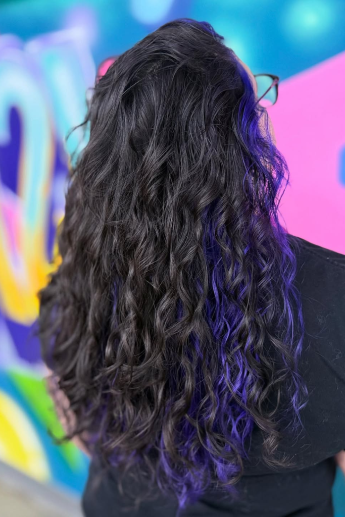 Curly peekaboo hair with burgundy underlights