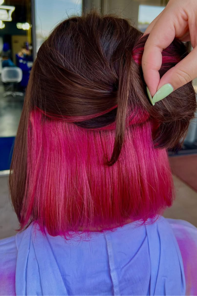Pink peekaboo hair under dark brown hair