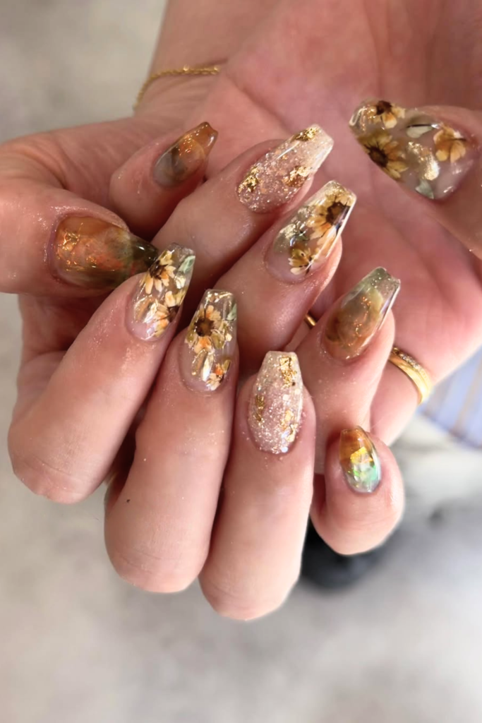 floral nails with gold foil and sunflower accents luxury detail