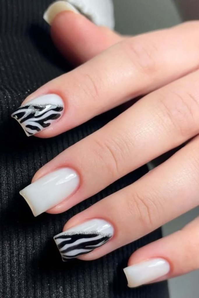 Milky white manicure featuring soft black zebra stripe accents