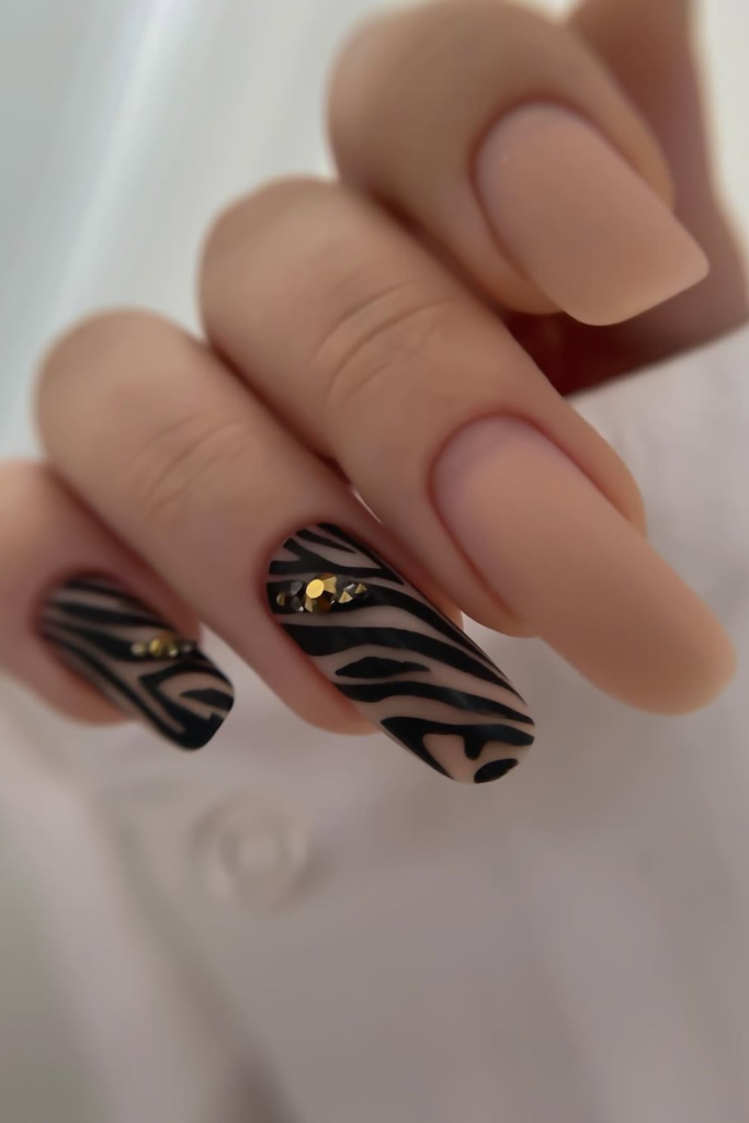 Matte nude manicure with modern animal print details