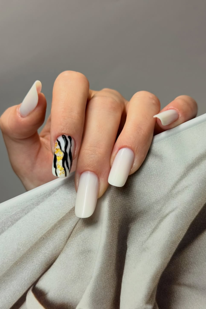 Animal print nail art with gold foil accents and glossy finish