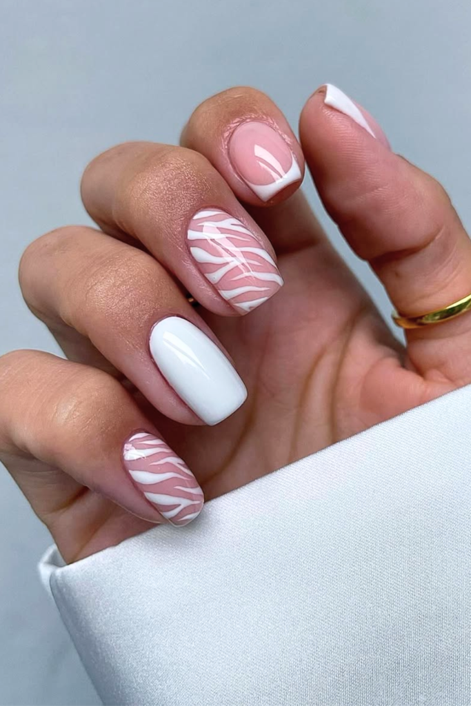 Minimalist nude manicure with a single zebra accent nail